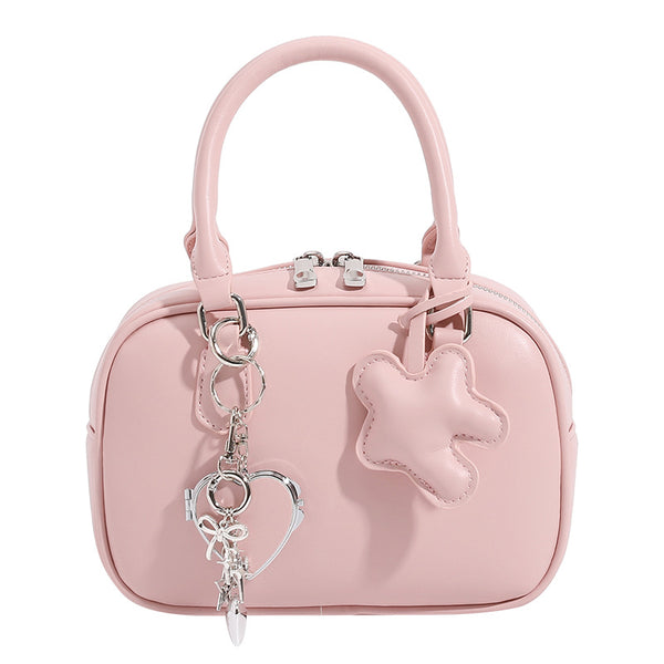 Small structured rounded-rectangle mini handbag with glossy leather-look finish, top zip closure, silver-tone hardware, and