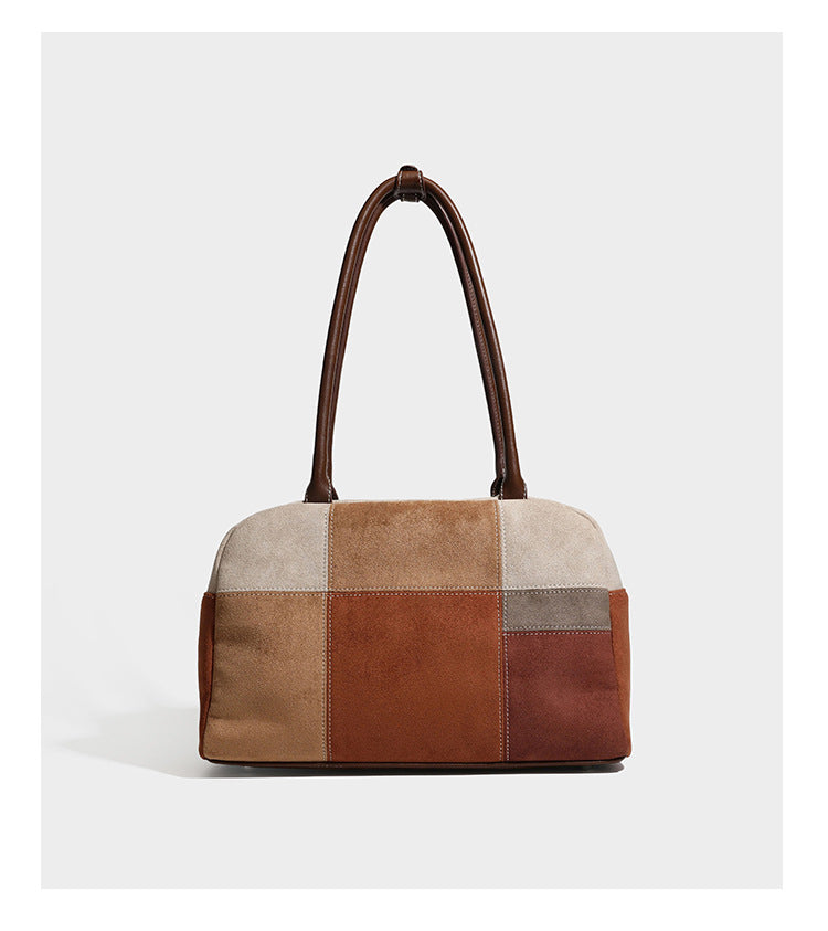 Boxy patchwork suede-look shoulder tote in tan, beige, rust, and brown panels with double brown straps and hanging doll
