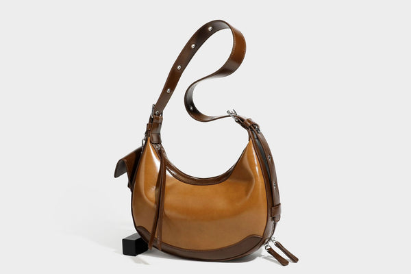Glossy leather-look crescent hobo shoulder bag with dark contrast trim, silver-tone hardware, and attached mini flap pouch