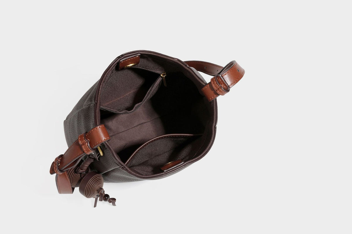 Hobo-Schultertasche in dunklem Espresso mit genarbter Oberfläche, warmen cognacfarbenen Details, verstellbarem schmalem Riemen, goldfarbenen Ringbeschlägen und geknotetem