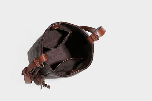 Hobo-Schultertasche in dunklem Espresso mit genarbter Oberfläche, warmen cognacfarbenen Details, verstellbarem schmalem Riemen, goldfarbenen Ringbeschlägen und geknotetem