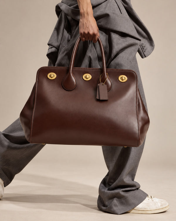 Structured leather-look tote bag with three gold-tone turn-lock closures and double rolled top handles, detail view 10