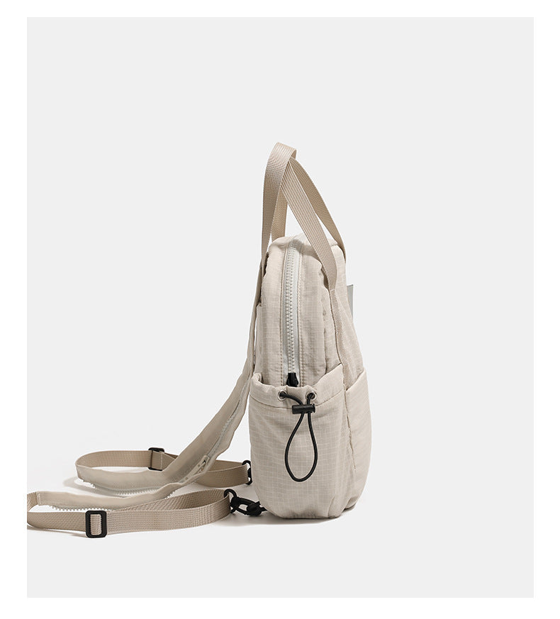 Mini rounded convertible backpack handbag in matte ripstop fabric with dual top handles, adjustable straps, and side, detail