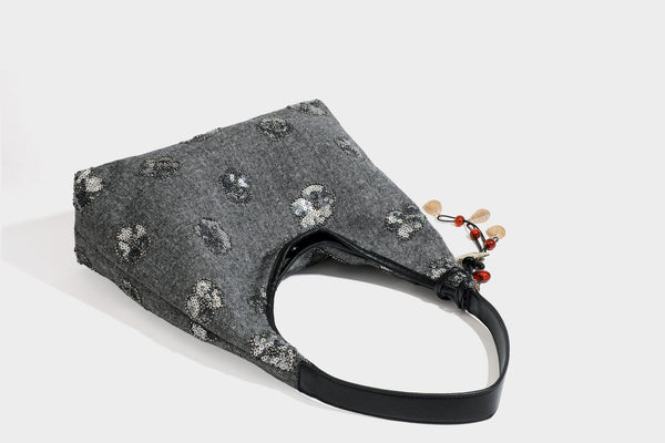 Lässig fallende, trapezförmige Schulter-Tote in Anthrazitgrau mit floralen Paillettenmotiven in Silber, Riemen in Lederoptik und herabhängendem Perlenbesatz