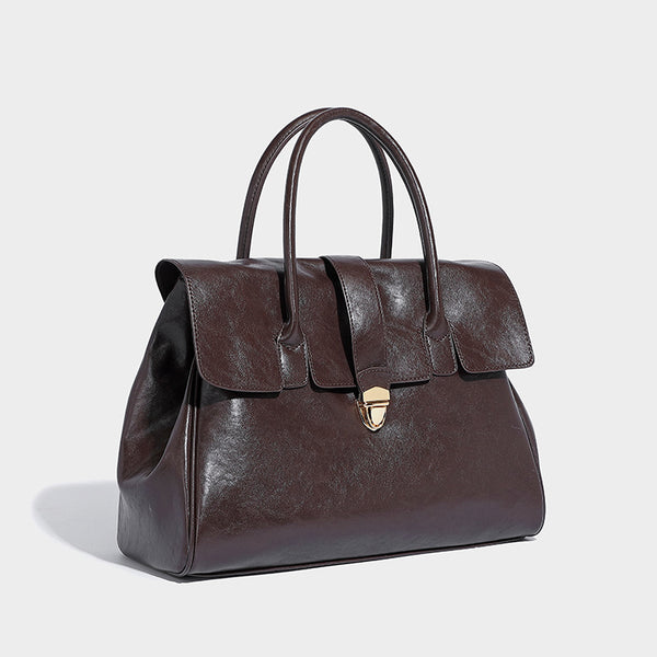 Strukturierte Henkeltasche im Shopper-Stil aus glänzender Lederoptik mit Überschlag, Mittelriemen, goldfarbenem Drehverschluss und zwei Henkeln