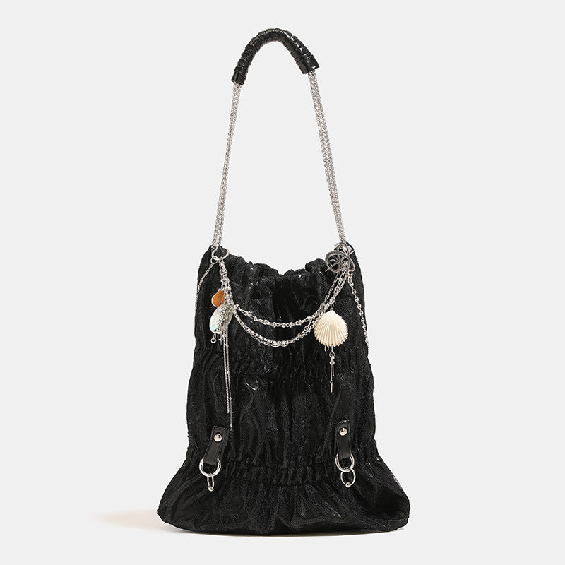Slouchy lace-texture bucket bag with silver-tone chain strap, draped chain hardware, and shell charms, detail view 9