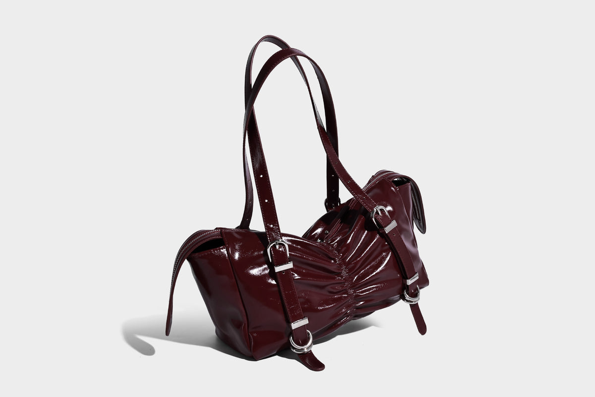 Glänzende, rechteckige Schultertasche mit Raffdetails, zwei verstellbaren Riemen, Reißverschluss oben und Schnallenbeschlägen in Silberoptik
