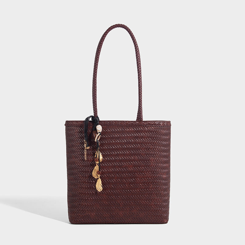 Structured woven herringbone tote bag with braided double shoulder handles in tan brown, shown with matching drawstring
