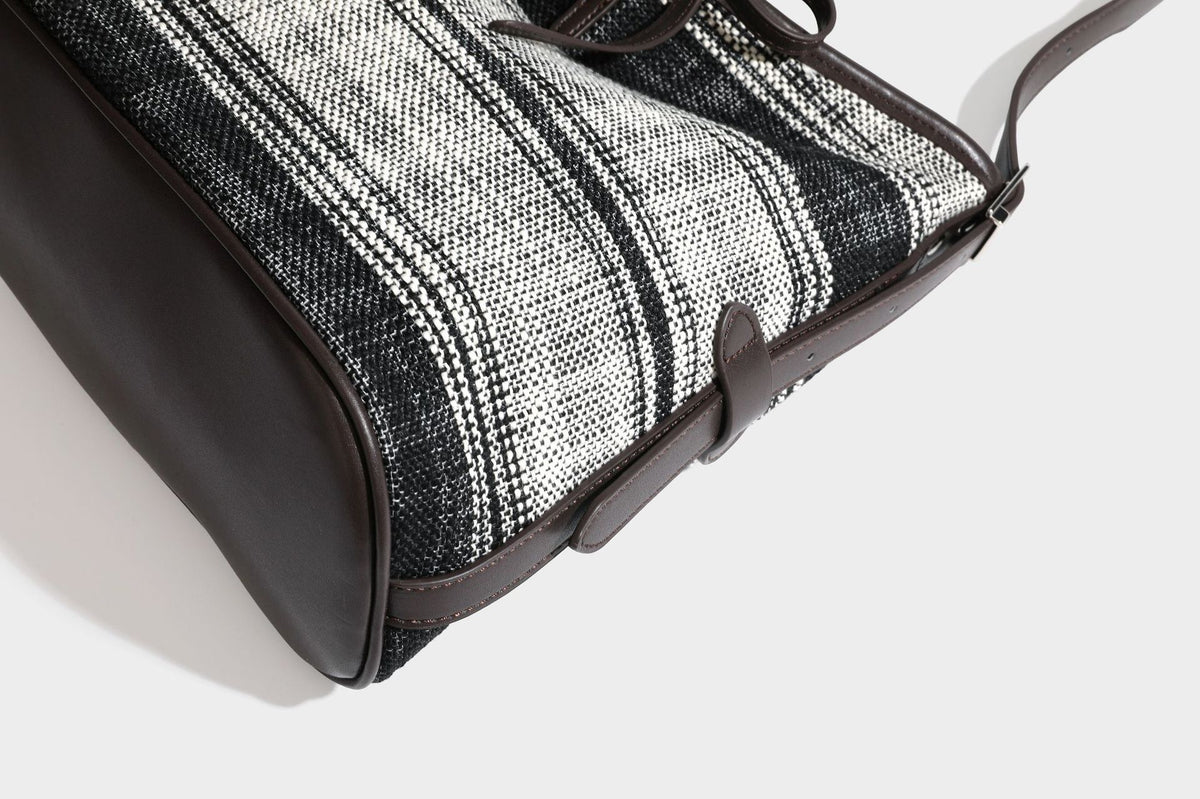 Schwarz-weiß karierte Hobo-Schultertasche aus gewebtem Material mit dunkelbrauner Einfassung in Lederoptik, Kordelzugverschluss und langem, verstellbarem