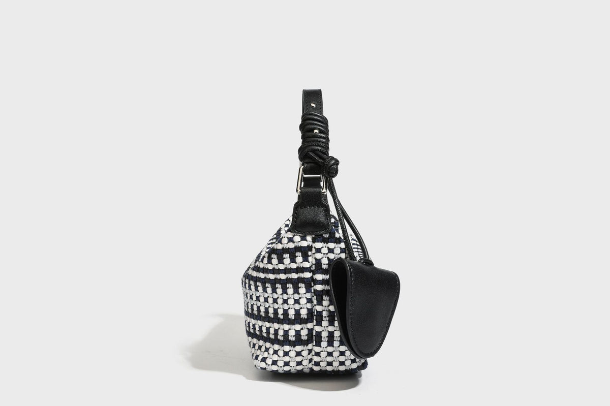 Small crescent shoulder bag in black-and-white woven textile with smooth black leather-look trim, zip-top closure, knotted