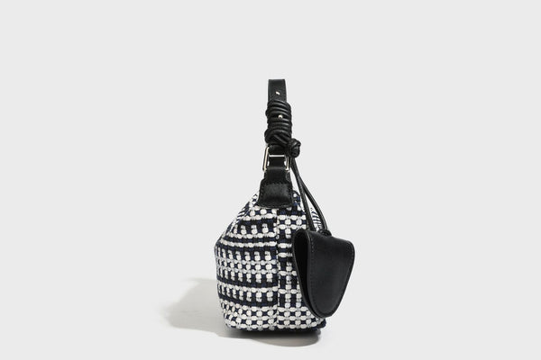 Small crescent shoulder bag in black-and-white woven textile with smooth black leather-look trim, zip-top closure, knotted