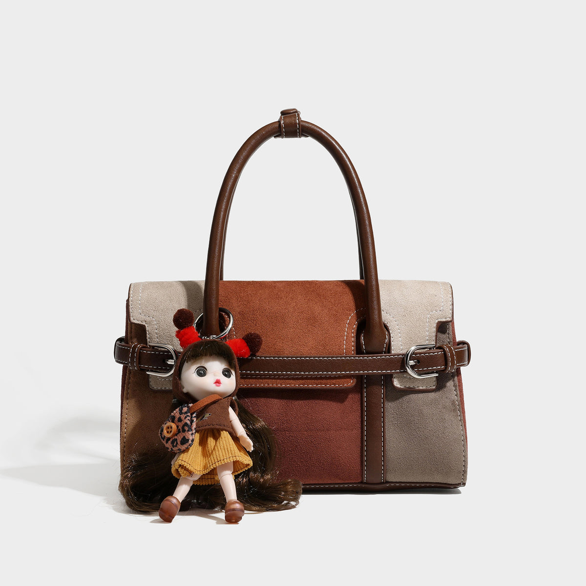 Structured color-block satchel bag in brown, rust, beige, and taupe suede-look panels with white topstitching, front buckle