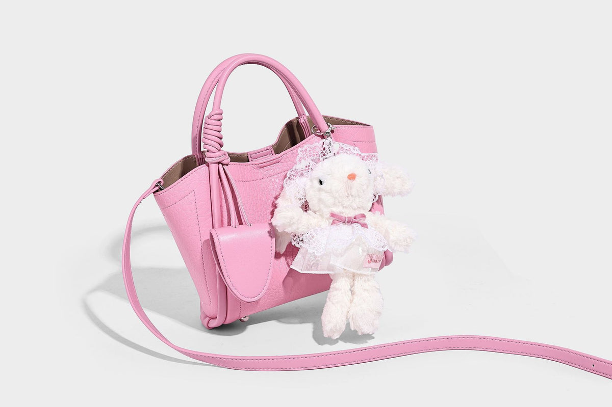 Structured mini tote bag in pebbled leather-look finish with knotted top handles, front flap pocket, and detachable shoulder