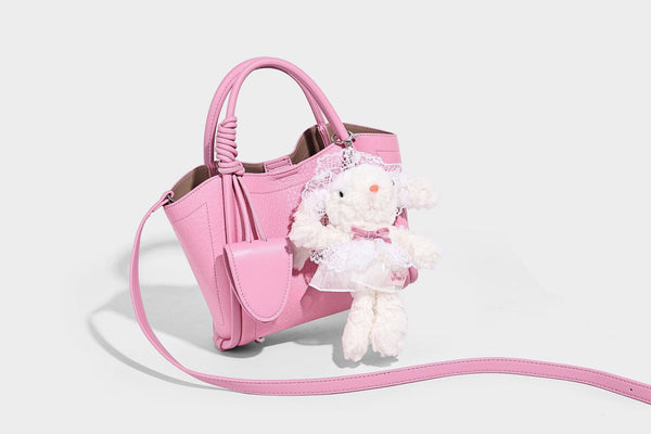 Structured mini tote bag in pebbled leather-look finish with knotted top handles, front flap pocket, and detachable shoulder