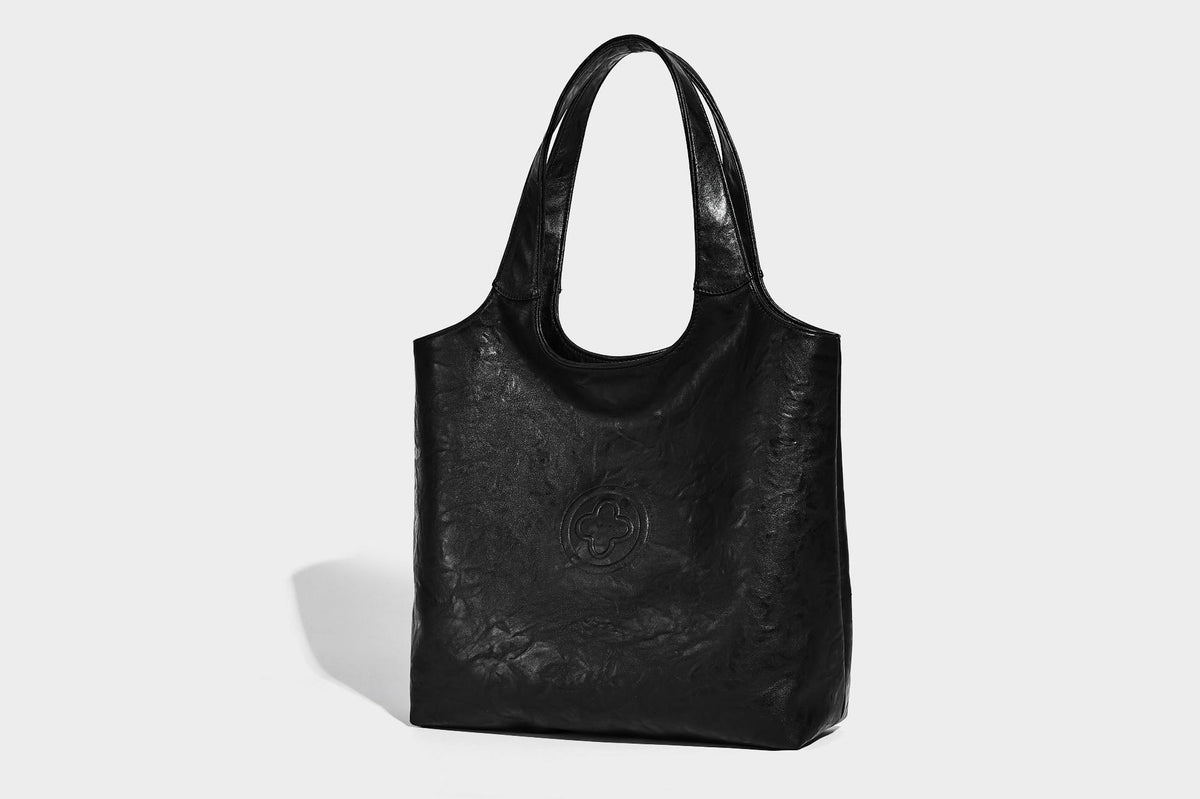 Large open-top tote bag with crinkled leather-look finish, long double shoulder straps, and embossed circular detail on