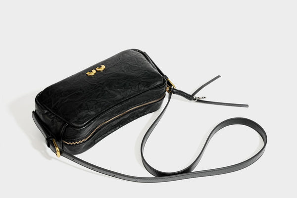 Compact black crinkled leather-look baguette shoulder bag with gold-tone arch hardware and adjustable strap, detail view 33