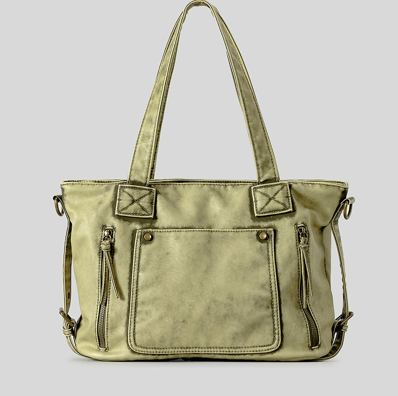 Distressed leather-look convertible tote bag with dual top handles, front zip and patch pockets, and adjustable shoulder