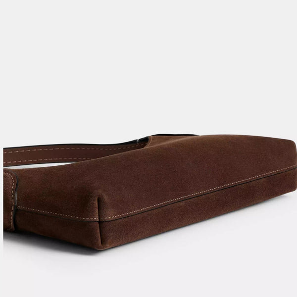 Slim crescent-silhouette shoulder bag in chocolate brown suede-look finish with contrast topstitching, top zip closure, thin
