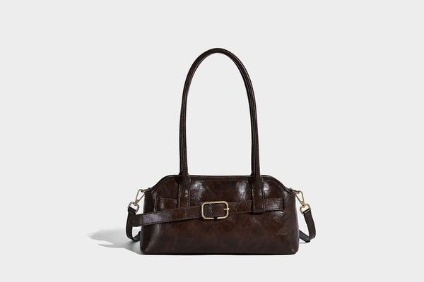 Strukturierte dunkelbraune Henkeltasche mit Öl-Wachs-Finish, vorderer Gürtelschnalle, goldfarbenen Beschlägen und zwei Tragegriffen, Detailansicht
