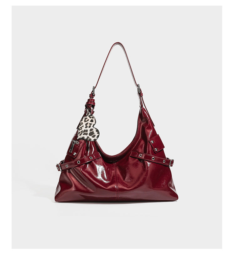 Glänzende, dunkelbraune Hobo-Schultertasche mit silberfarbenen Ösen am Riemen, vorderer Reißverschlusstasche und Herzmotiv im Leopardenprint