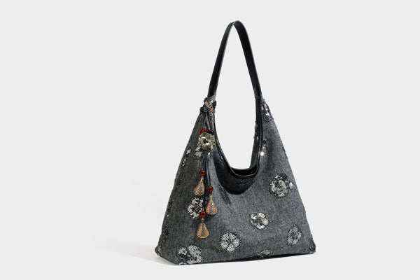 Lässig fallende, trapezförmige Schulter-Tote in Anthrazitgrau mit floralen Paillettenmotiven in Silber, Riemen in Lederoptik und herabhängendem Perlenbesatz