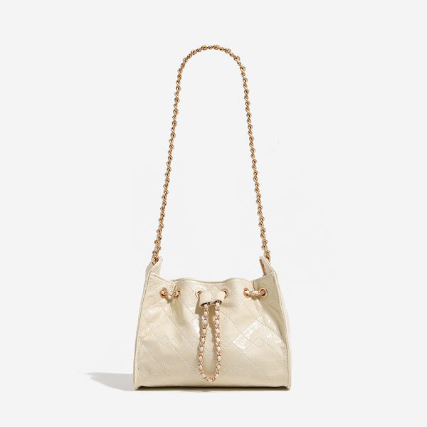 Glossy diamond-quilted drawstring bucket bag with gold-tone chain strap and eyelet hardware, detail view 7