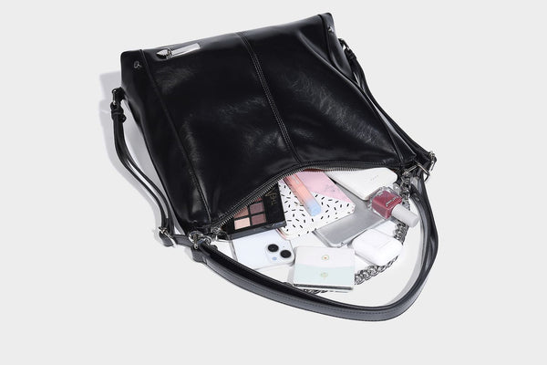 Glänzend schwarze Hobo-Shopper-Tasche mit silberfarbenem Kettenakzent, Reißverschluss oben und langen Schulterriemen, Detailansicht 25