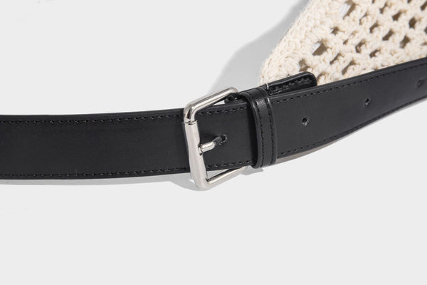 Cream openwork crochet hobo bag with black leather-look strap and trim patch accent, slouchy teardrop silhouette, detail view