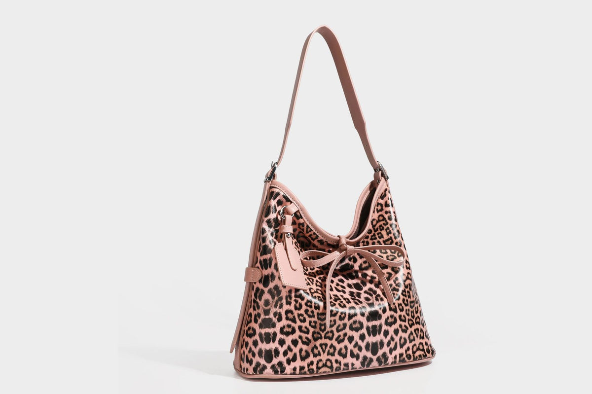 Slouchy leopard print shoulder hobo bag with black leather-look trim, tie-top closure, and single long strap, detail view 23
