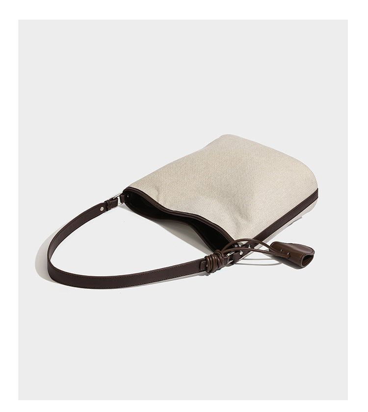 Oatfarbene Canvas-Schultertasche mit dunkelbraunem Besatz in Lederoptik, langem verstellbarem Riemen und angebrachter Mini-Tasche mit Überschlag, Detailansicht