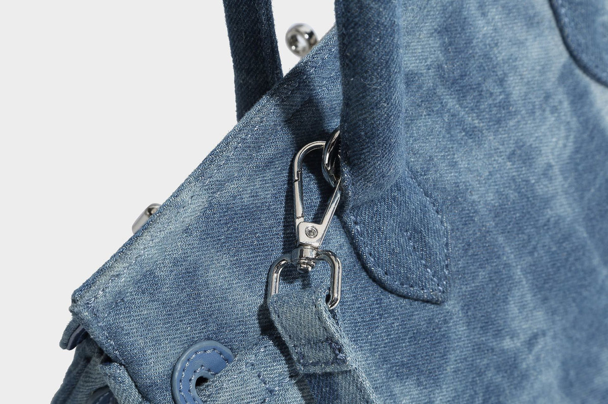 Strukturierte Patchwork-Henkeltasche aus gewaschenem Denim mit gerollten Tragegriffen, Überschlag mit Drehverschluss, aufgesetzten Fronttaschen und, Detail