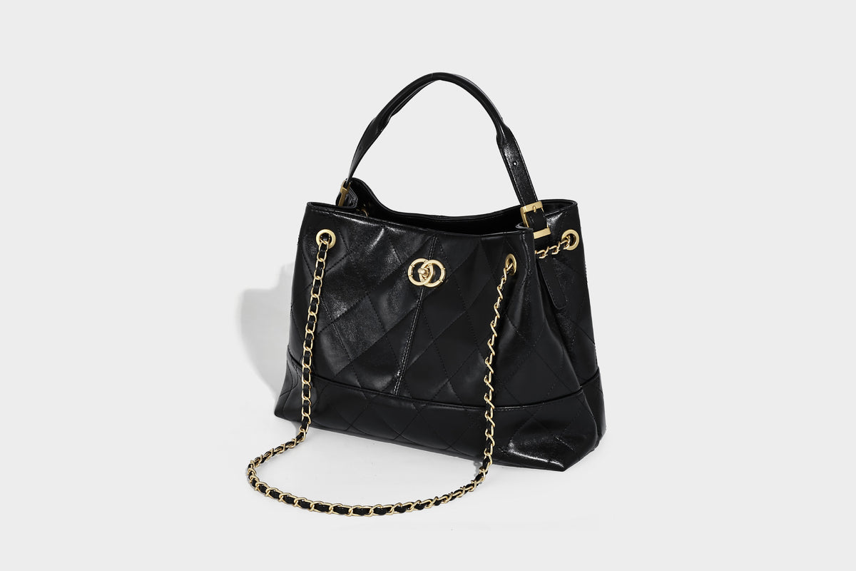 Gesteppte zweifarbige Schultertasche mit goldfarbener Kettenriemen und ineinandergreifendem Ringemblem im apricot-schwarzen Colorblock-Design, Detailansicht