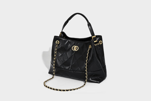Gesteppte zweifarbige Schultertasche mit goldfarbener Kettenriemen und ineinandergreifendem Ringemblem im apricot-schwarzen Colorblock-Design, Detailansicht