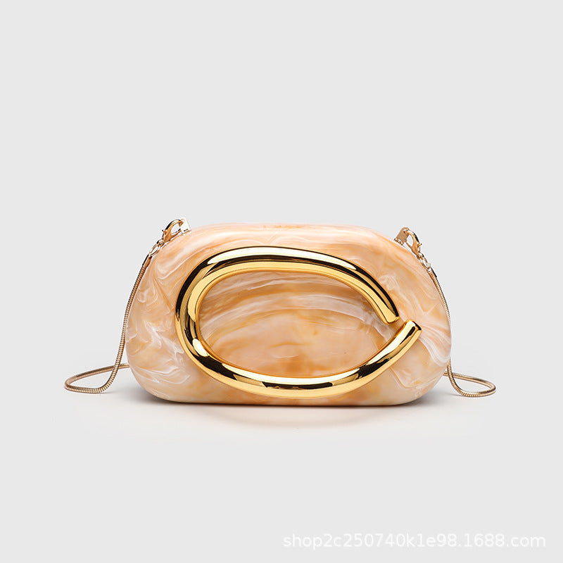 Kleine rechteckige Crossbody-Clutch mit abgerundeten Ecken, oversized poliertem C-förmigem Goldgriff und schmalem Goldkettenriemen, Detailansicht
