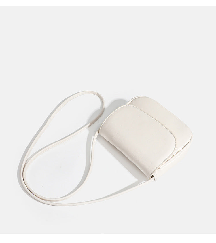 Compact rounded rectangular flap crossbody bag with glossy leather-look finish and long shoulder strap, detail view 18