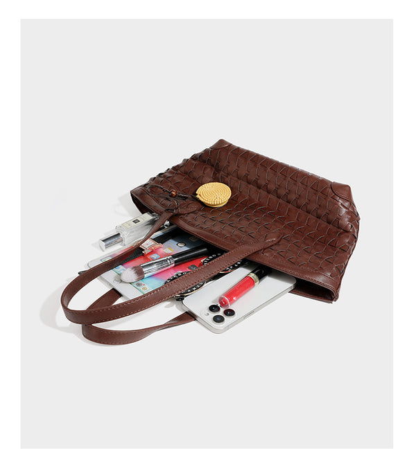 Large leather-look tote bag with geometric woven emboss, double shoulder straps, and round woven cord charm in brown, detail