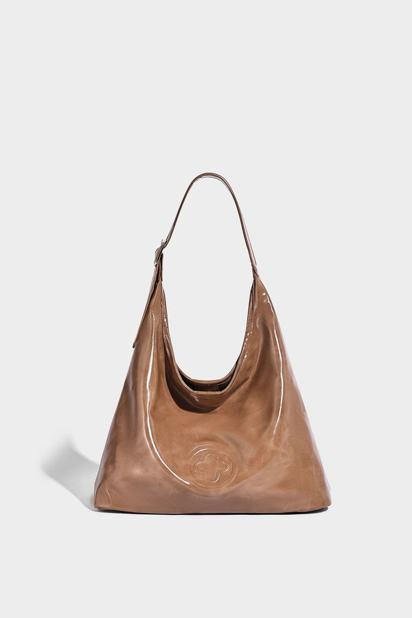 Glossy slouchy hobo shoulder bag with adjustable strap and embossed floral emblem, detail view 13
