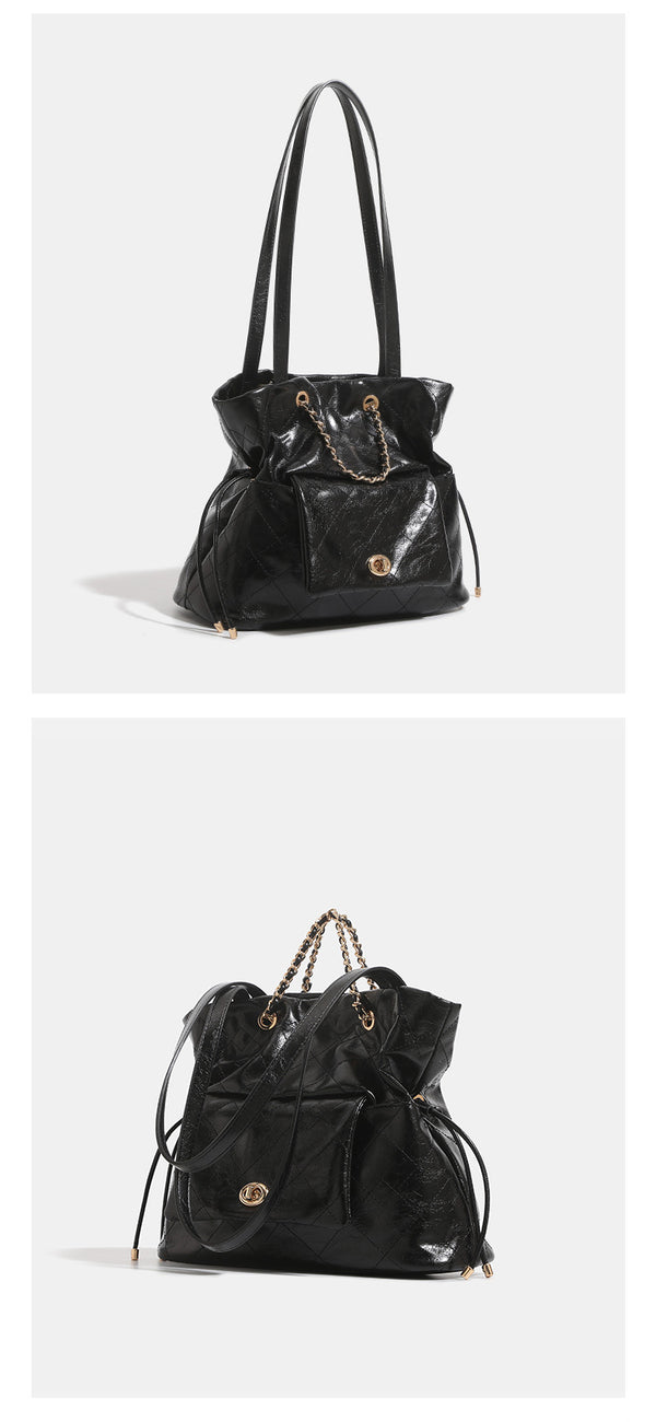 Black glossy diamond-quilted bucket tote bag with gold-tone chain accent, turn-lock front flap pocket, drawstring side ties