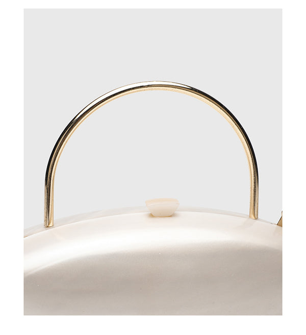Shell-shaped pearlescent top-handle clutch bag with arched gold-tone metal handle and gold chain strap, detail view 18