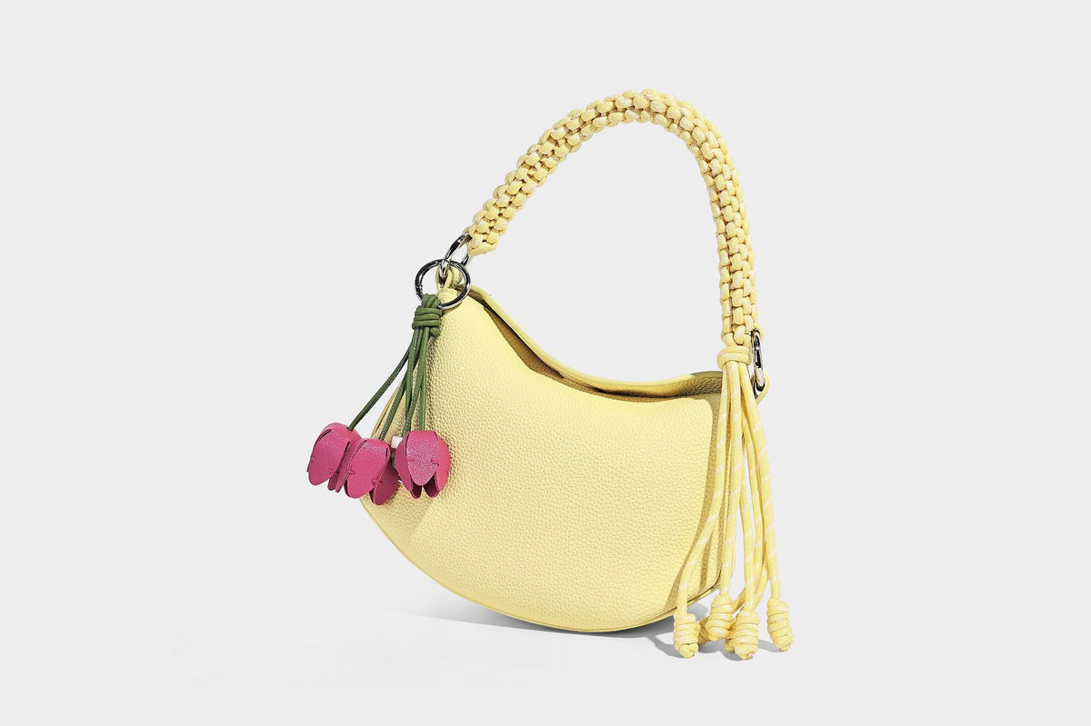Small crescent half-moon bag in pebbled leather-look finish with braided top handle, silver-tone ring hardware, and, detail