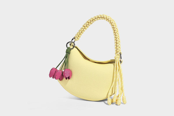 Small crescent half-moon bag in pebbled leather-look finish with braided top handle, silver-tone ring hardware, and, detail
