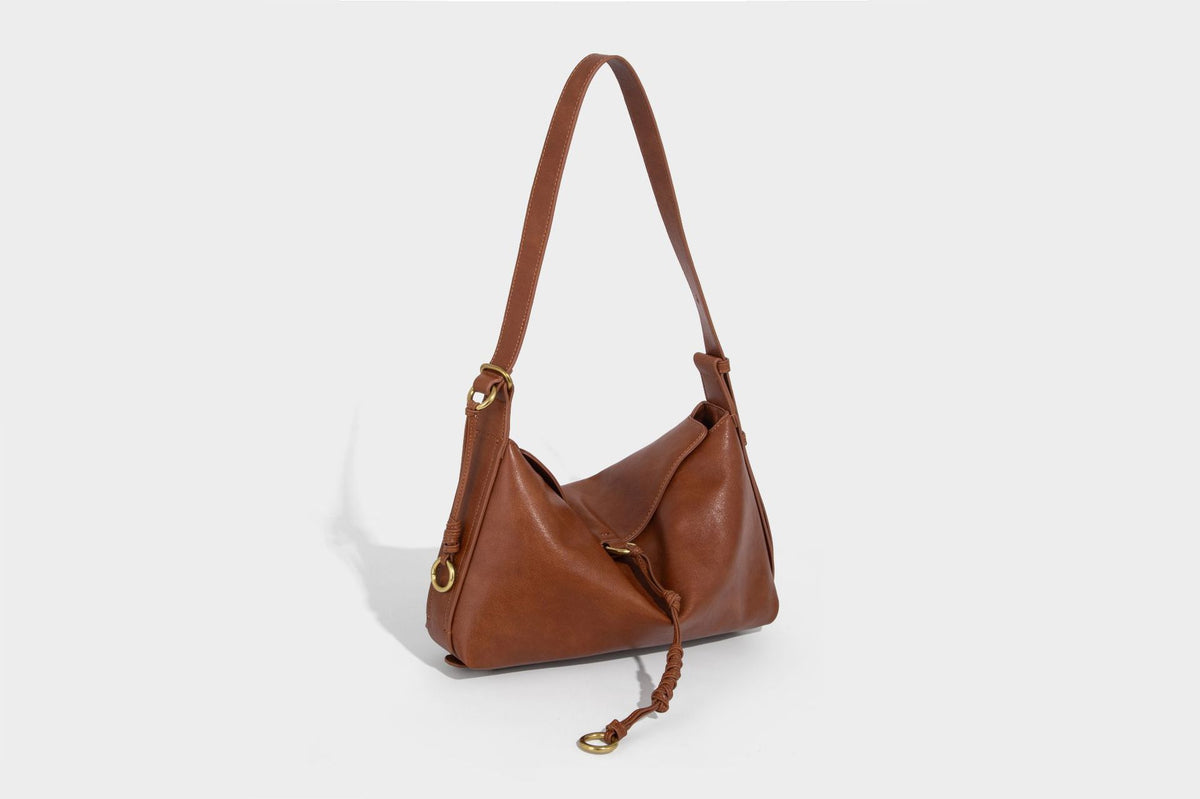 Slouchy brown leather-look shoulder bag with knotted drawcord tie closure, gold-tone ring hardware, and long adjustable