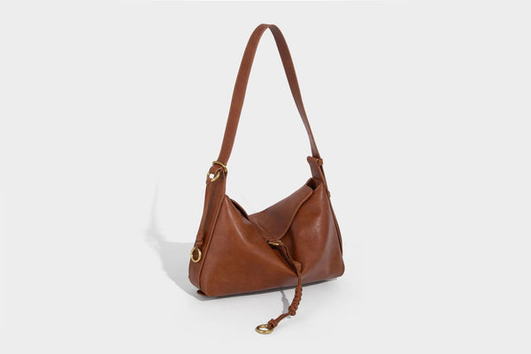 Slouchy brown leather-look shoulder bag with knotted drawcord tie closure, gold-tone ring hardware, and long adjustable