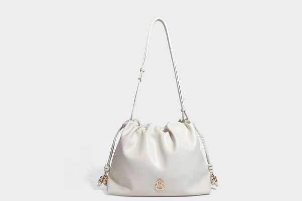 Slouchy ruched drawstring shoulder bag in smooth leather-look finish with gold-tone emblem and slim adjustable strap, detail