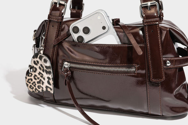 Strukturierte Schultertasche in glänzender Lederoptik mit abgerundetem Korpus, silberfarbenen Beschlägen, Reißverschlussfach auf der Vorderseite und Leopardenmuster