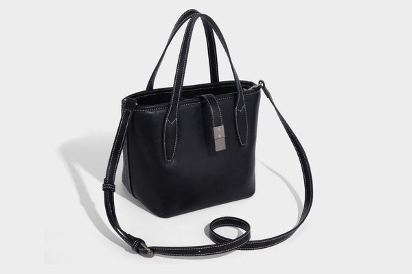 Compact structured bucket tote bag with pebbled textured finish, dual top handles, silver-tone lock hardware, and detachable