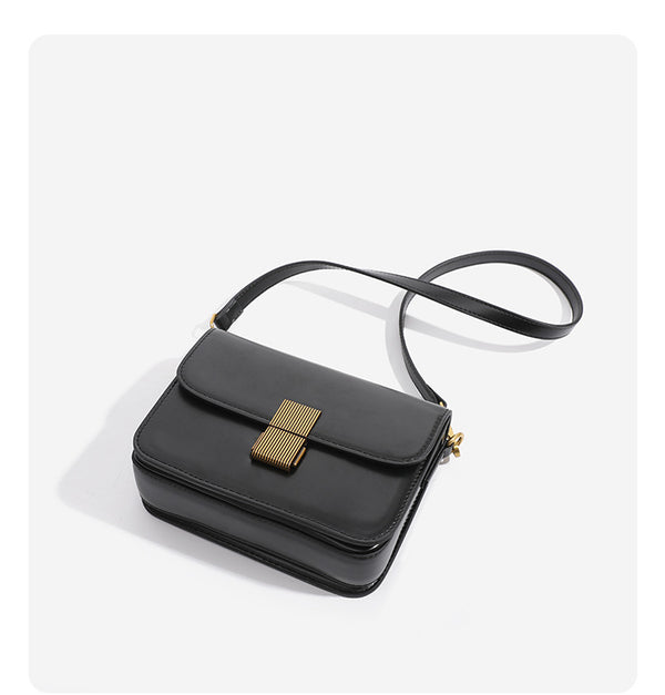 Mini structured black flap crossbody bag with gold-tone ribbed rectangular clasp and adjustable shoulder strap, detail view 9