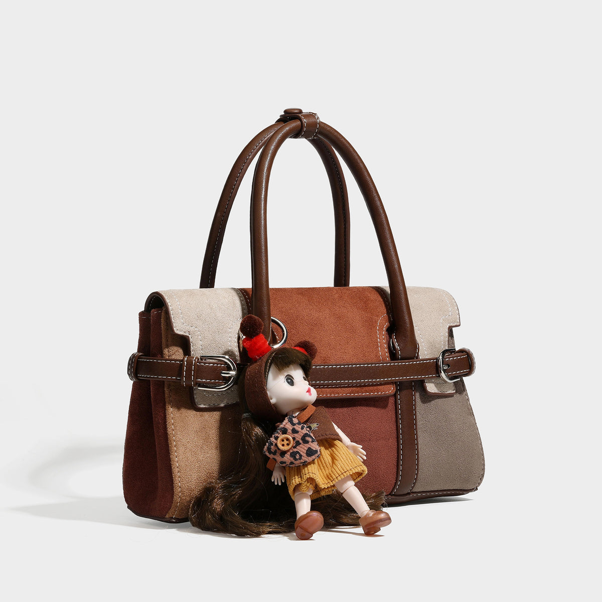 Structured color-block satchel bag in brown, rust, beige, and taupe suede-look panels with white topstitching, front buckle