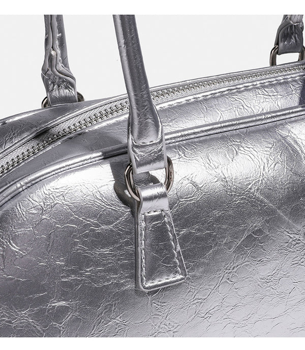Rounded rectangular shoulder bag with glossy crinkled finish, dual long handles, top zip closure, and gingham ribbon bow