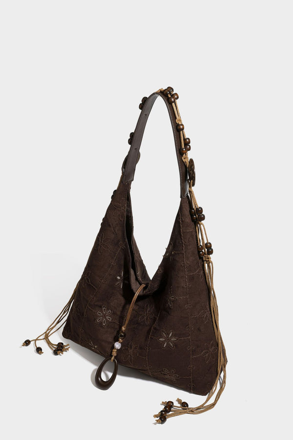 Dunkelbraune bestickte Hobo-Shopper-Tasche mit perlenverziertem Schulterriemen in Lederoptik, verknoteten Quastenbändern und ovalen Ringbeschlägen